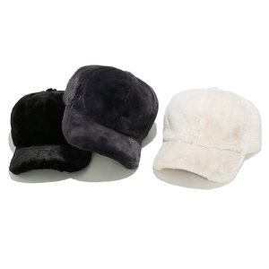 Detailed close-up of plush faux fur texture on black, grey, and white winter baseball caps