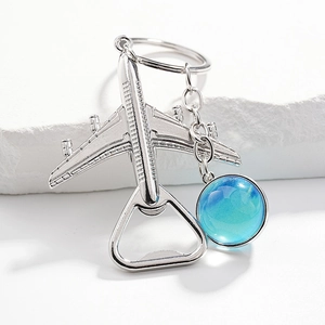 Macro shot of silver airplane bottle opener keychain with a blue glass pendant detail