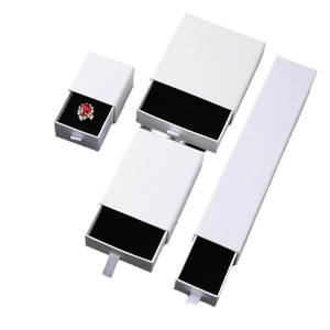 Elegant white drawer jewelry boxes with black velvet inserts and ribbon pull handles