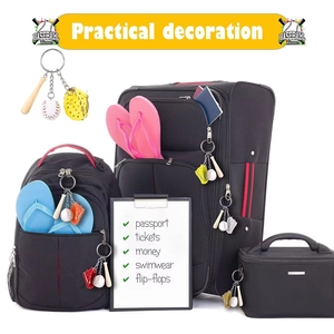 Detailed baseball keychain set with bat and glove charms shown hanging on a travel bag