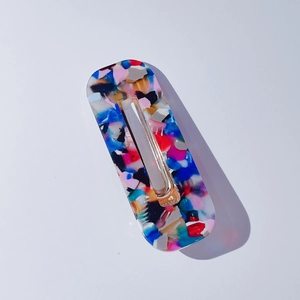 Détail d'une barrette en acétate mosaïque colorée avec clip bec de canard doré