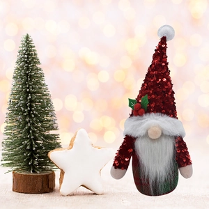 Détail d'un lutin de Noël avec bonnet à paillettes rouges et décor de houx