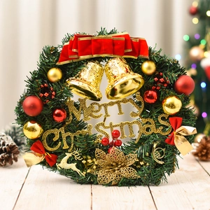 Close-up of Christmas wreath with golden bells, red velvet bow and Merry Christmas sign