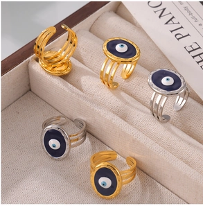 Detailed view of evil eye open rings with blue enamel and gold finish in a jewelry box