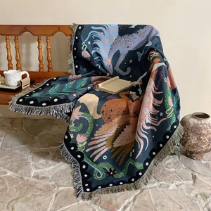 Detailed view of woven unicorn throw blanket with bird patterns and decorative fringe