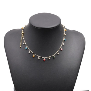Detail of colorful heart pendants on a gold chain displayed on a black neck mannequin