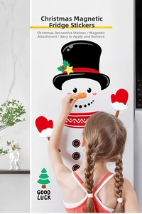 Close-up of a girl placing a cute snowman magnet with Good Luck tree on the fridge
