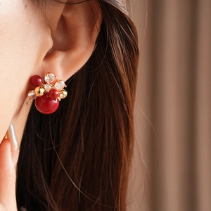 Detailed close-up of floral pearl stud earrings with red beads and zircon accents
