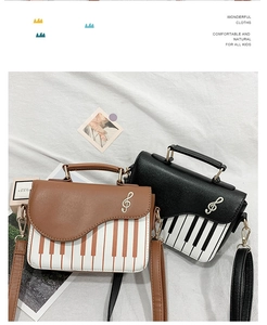 Detail of piano keyboard print and golden treble clef metal buckle on crossbody bags