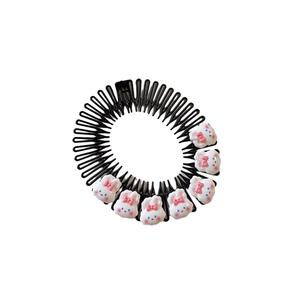 Black plastic hair comb with seven cute white cartoon bunnies and pink bows on white background