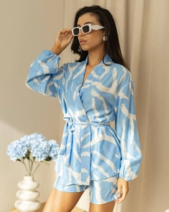 Detail of light blue floral loungewear set featuring long-sleeve tie-waist top and shorts