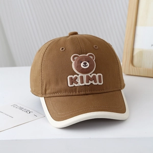 Détail d'une casquette bébé avec écusson ours en caoutchouc 3D et bordure passepoilée