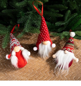 Three plush Christmas gnome hanging ornaments in red, white and grey on pine branches