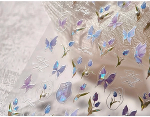 Macro detail of 3D embossed butterfly and tulip nail stickers with pearl texture accents