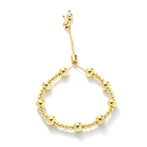 Detail of adjustable gold beaded bracelet featuring polished metallic finish and slide clasp