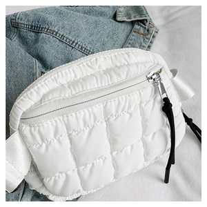 Close-up of white quilted puffer waist bag featuring diamond pattern and silver zipper detail