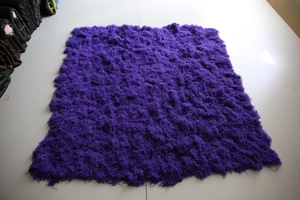 Macro detail of high-density purple artificial moss turf with long plush fiber texture