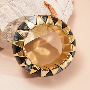 Close-up of geometric acrylic bangle with gold metal and marble texture accents