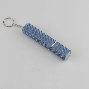 Close-up of a blue rhinestone encrusted perfume atomizer with silver keychain