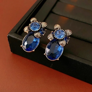 Vintage baroque earrings with deep blue oval gemstones and bronze floral metal texture