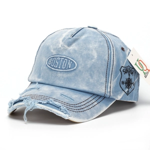 Detailed view of frayed brim and Boston embroidery on distressed denim baseball cap