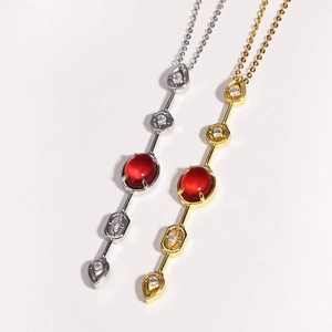 Close-up of gold and silver plated necklaces with red gemstone pendants and fine details
