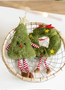 Close-up of plush Christmas tree and wreath dolls with knitted legs in a woven basket