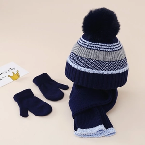 Détail à plat d'un ensemble bonnet à pompon, écharpe et moufles en tricot rayé