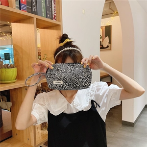 Détail d'une trousse à maquillage en toile à motif zèbre avec fermeture éclair