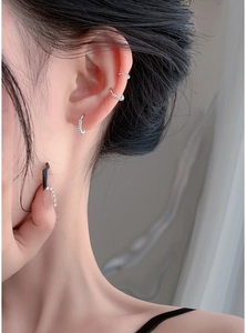 Close-up of S999 sterling silver hoop earrings with sparkling zircon on model's ear