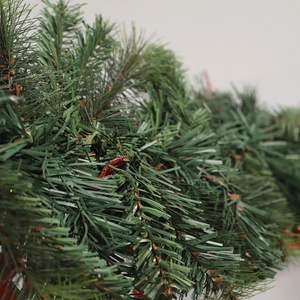 PVC Christmas artificial green garland with festive red accents and dense pine needle texture