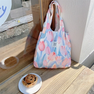 Dettaglio della borsa shopper in tela con fiori di tulipano su un davanzale soleggiato