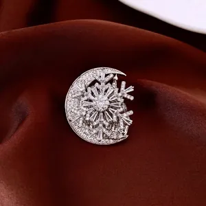 French style zircon moon and snowflake brooch on elegant red fabric backdrop