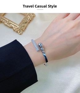 Detail of silver open bangle with paved zircons and three gradient steel beads on wrist