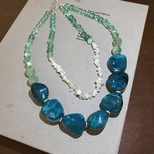 Close-up of double-layer acrylic necklace with green beads and blue marble resin stones