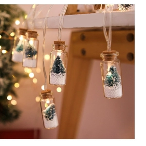 Close-up of LED wishing bottle string lights with miniature trees and fake snow detail