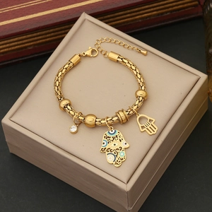 Detail of a golden Hamsa Hand bracelet with blue eye pendant and sparkling crystals
