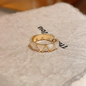 Detail of vintage gold butterfly style ring with triangular opals on a textured card