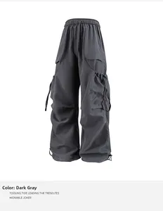 Dettaglio dei pantaloni cargo grigio scuro con coulisse regolabile e grandi tasche laterali