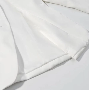 Vue détaillée du tissu blanc et de la doublure de qualité supérieure de l'ensemble col en V