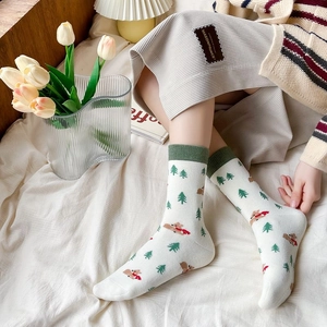 Detail of white cotton socks with cute brown bear and green pine tree embroidery patterns