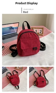 Detail view of red corduroy backpack showing flap pocket and adjustable straps
