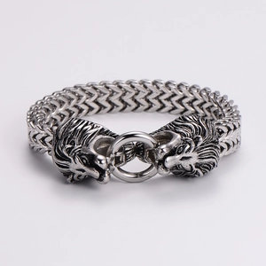 Detail of vintage silver double lion head bracelet with intricate carved metal texture