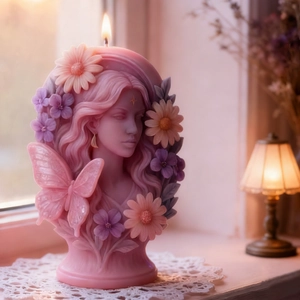 Artistic butterfly fairy goddess candle with floral details on lace tablecloth