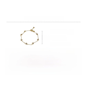 Detail of gold chain bracelet with green zircon and cat-eye stone in vintage style