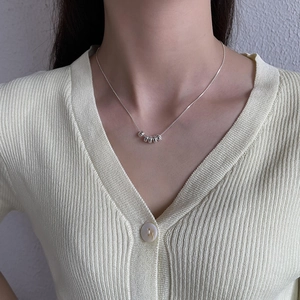 Polished silver beaded necklace on model neck showing elegant snake chain draping