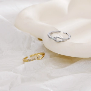 Detail of knotted zircon ring with sparkling cubic zirconia on a minimalist gold band