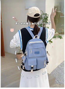 Detail of light blue canvas backpack with buckles and functional side pockets for travel