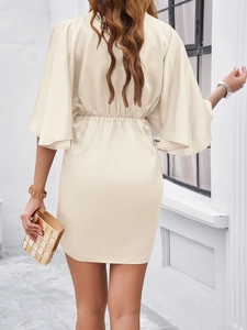 Rear view of a beige mini dress featuring butterfly sleeves and a cinched waist design