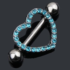 Macro view of silver heart nipple ring with blue rhinestones on black mirror